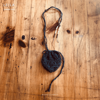 leila satchel necklace in transformation grey cotton portfolio picture on table